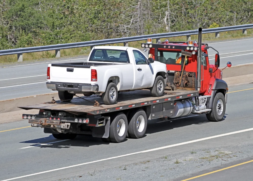Emergency Towing 3 pickup truck loaded onto tow truck flatbed